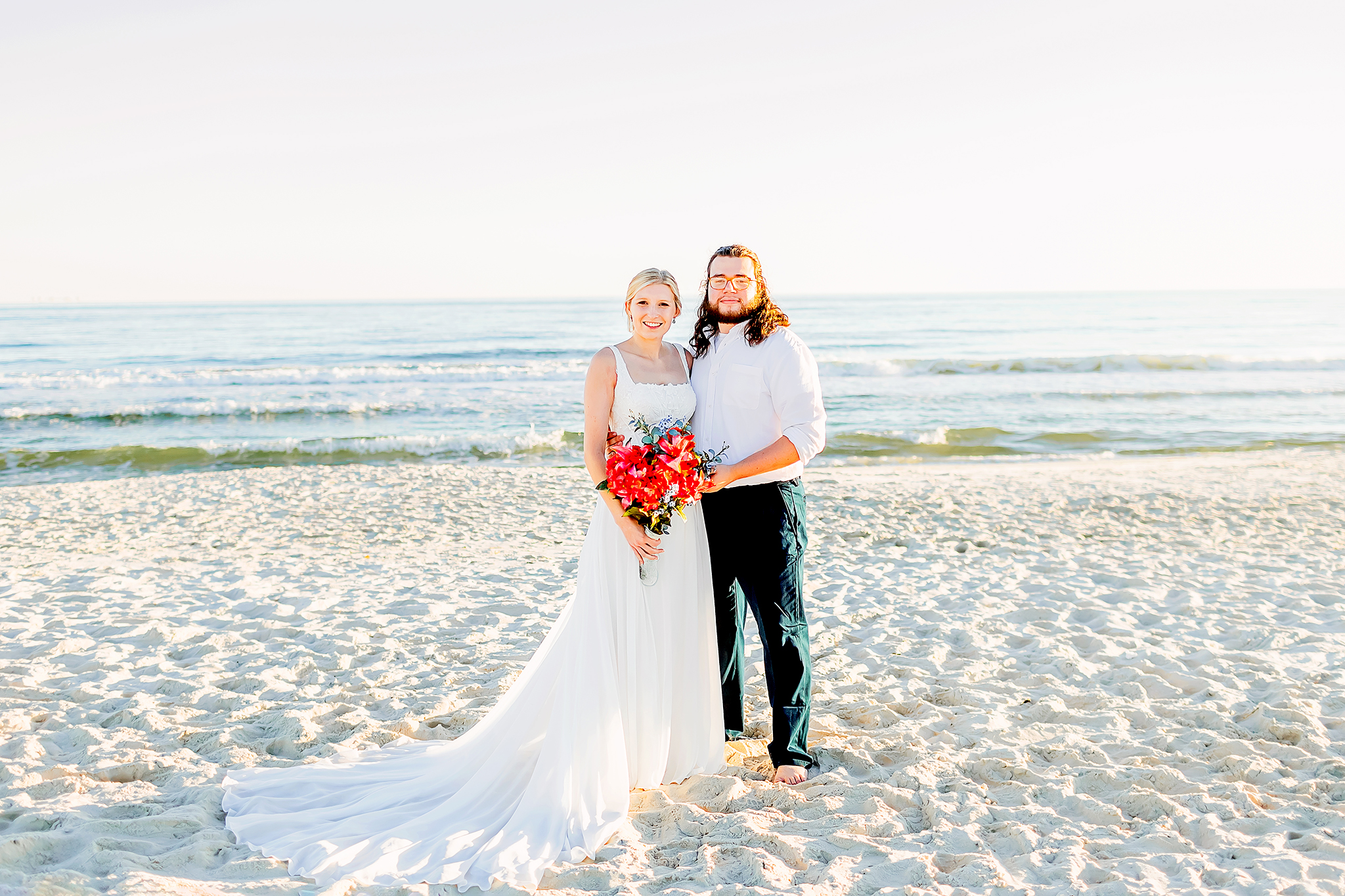 Bride and groom pose for a couple portrait on the beach of Gulf Shores
