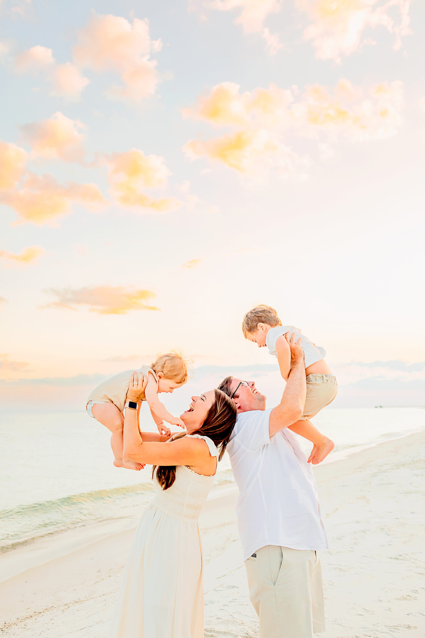 family of four pose for candid photography on the beach of Gulf shores