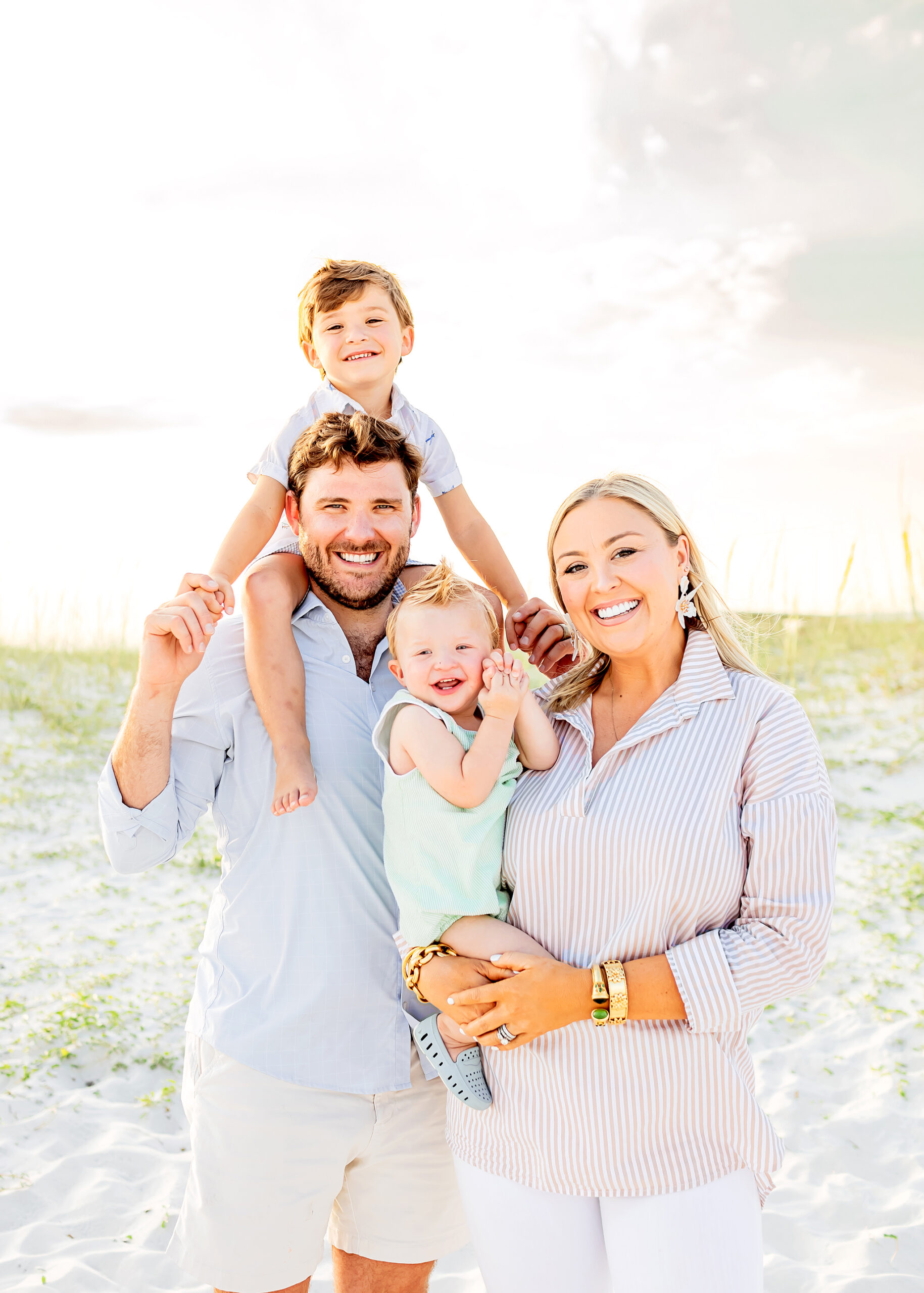 Beautiful family of four poses for photos taken by orange beach photographer