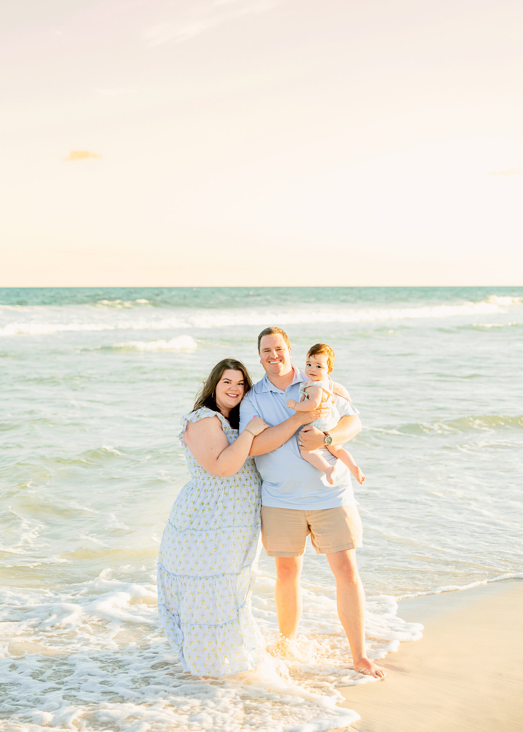 Family of three poses in the water at the beach for gulf shores photographer