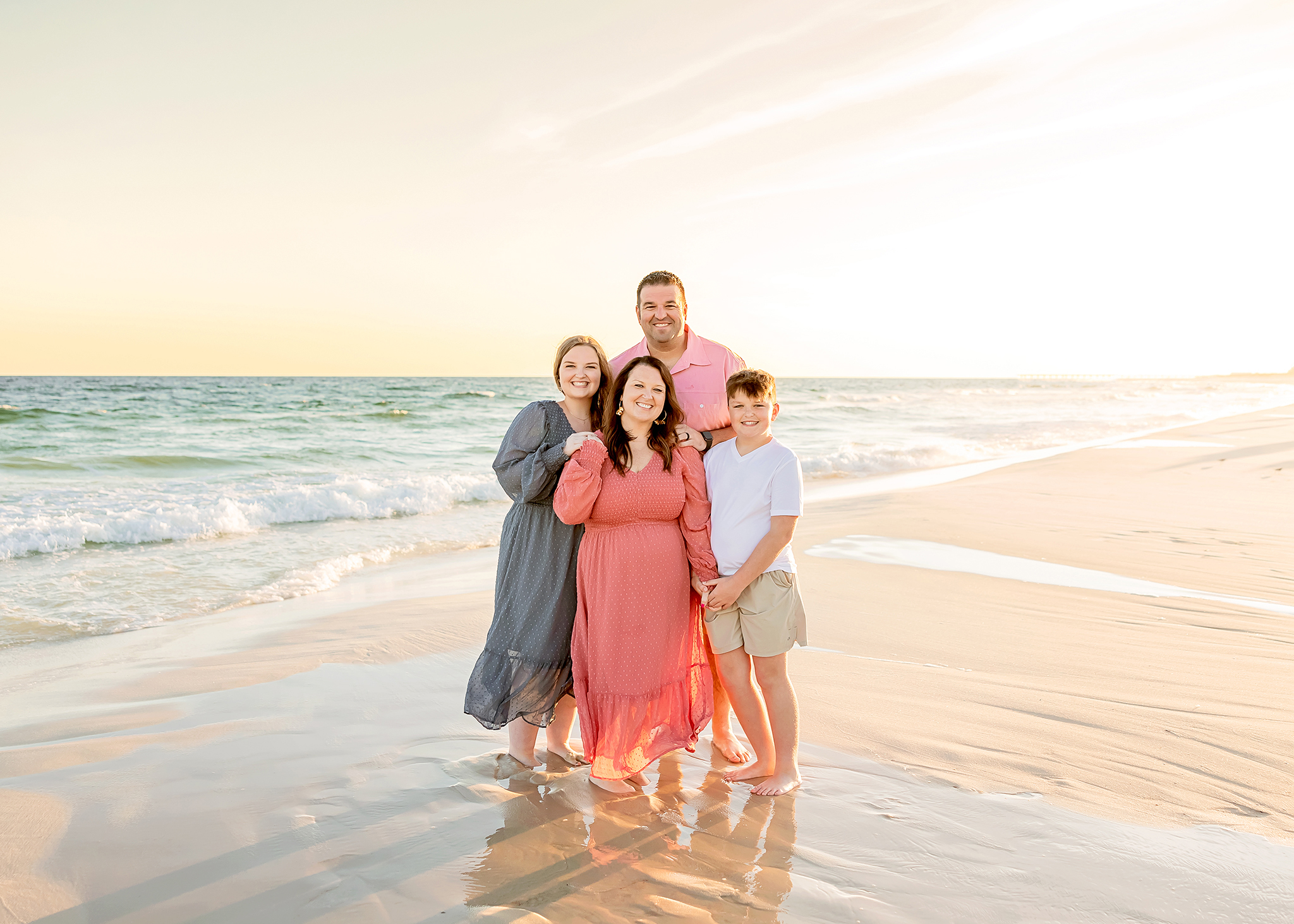 Family poses in the ocean for gulf shores photographer