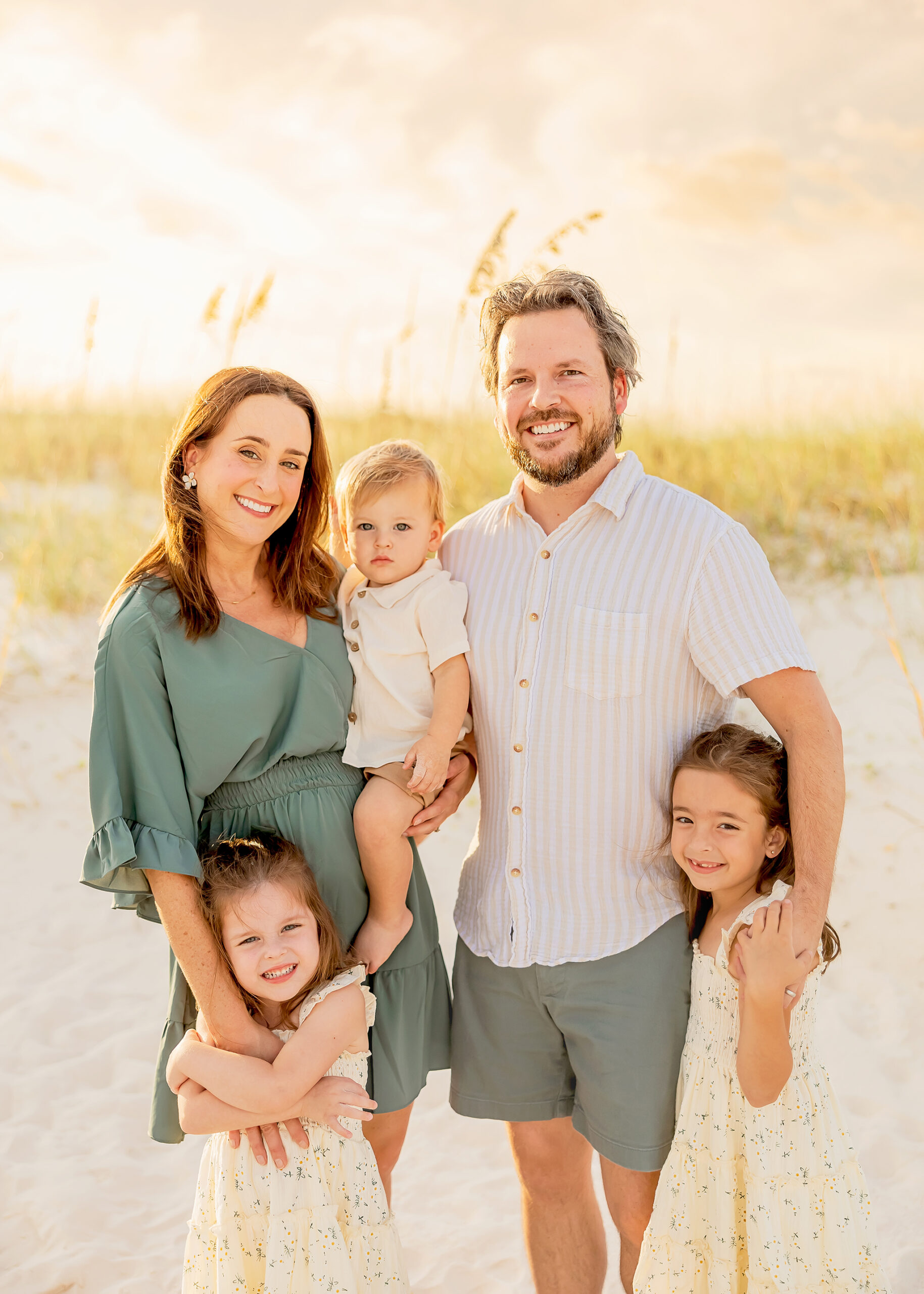 Family poses by the dunes for photos captures by gulf shores photography
