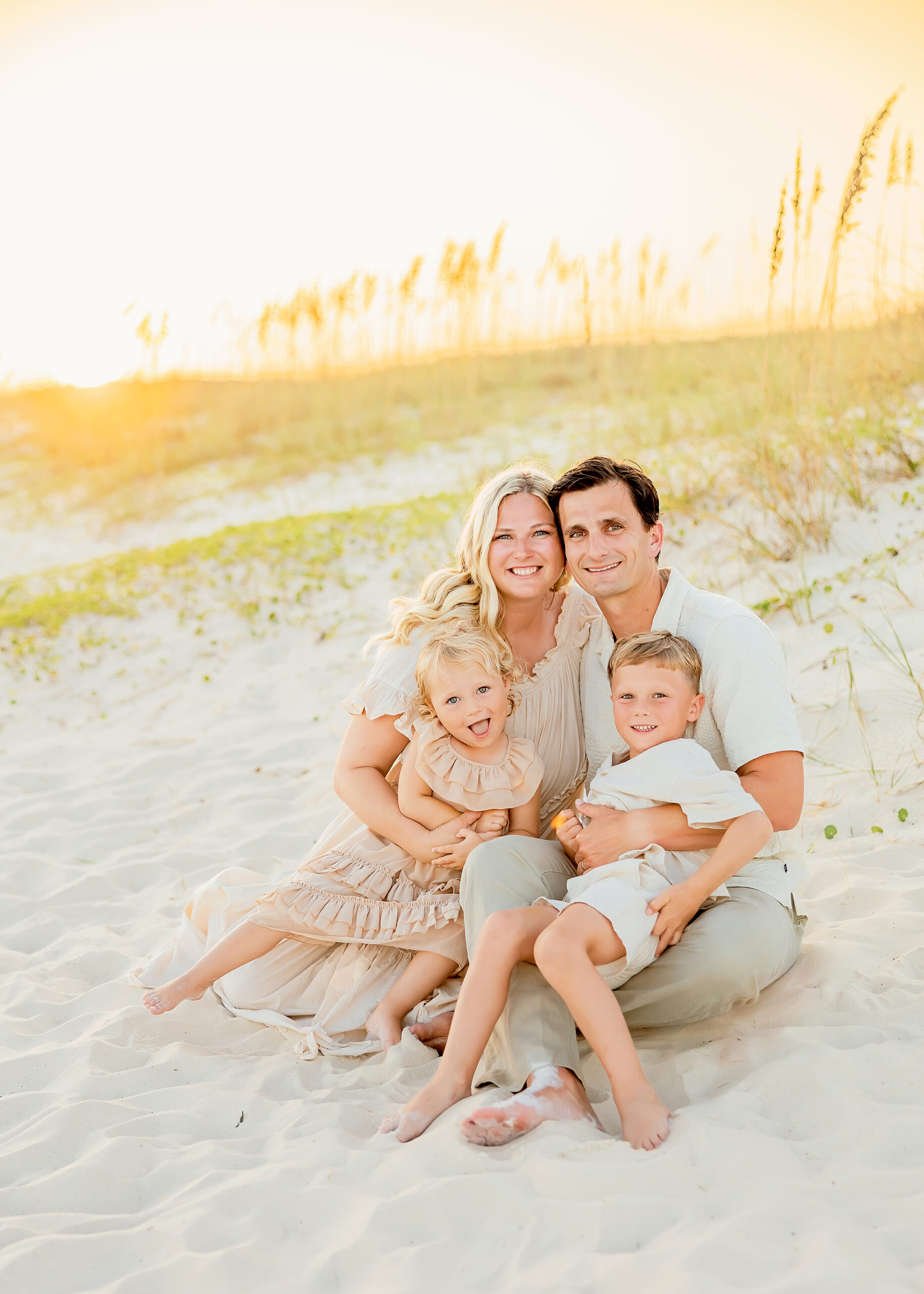 Family snuggling for beach photos taken by orange beach photographer